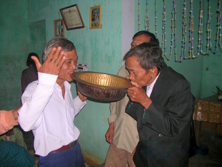 Hai người cha của cô dâu và chú rể cùng cắn vào thau đồng.