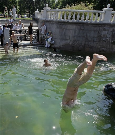 Mọi người tập trung tránh nắng bất kỳ nơi đâu có nước, ngay kể cả tại vòi phun nước ở quảng trường Manezhnaya của thủ đô Mátxcơva (ngày 15-7).