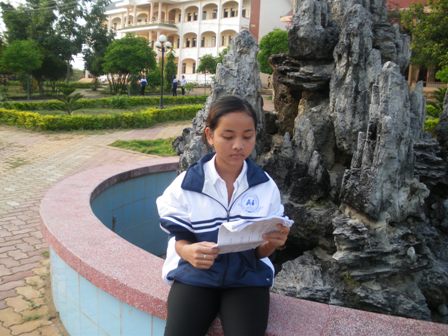 H'Tuy Niê ngồi học bên khuôn viên trường.