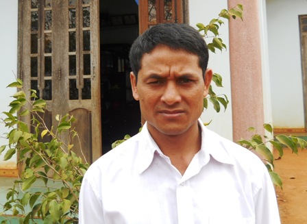 Anh Y Hăn Niê trước ngôi nhà của mình.