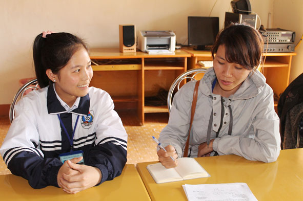 Đinh Thị Mỹ Duyên (bên trái) chia sẻ với phóng viên về những thành tích trong học tập và hoạt động Đội