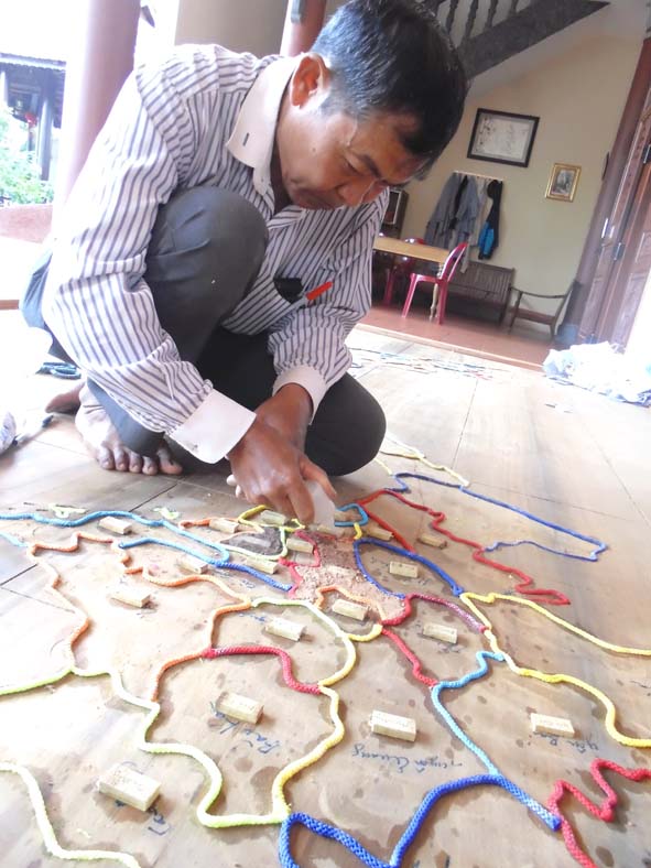 Nghệ nhân Võ Văn Hải cặm cụi, tỉ mẩn làm bản đồ được thiết kế từ đất xin tại Nghĩa trang Liệt sĩ của 63 tỉnh, thành