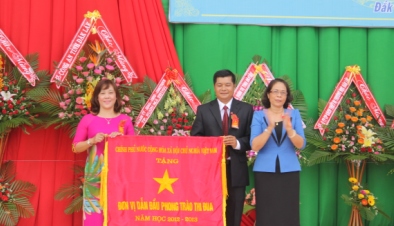 Phó Chủ tịch UBND tỉnh Mai Hoan Niê Kdăm  trao Cờ đơn vị dẫn đầu của Thủ tướng Chính phủ cho tập thể nhà trường