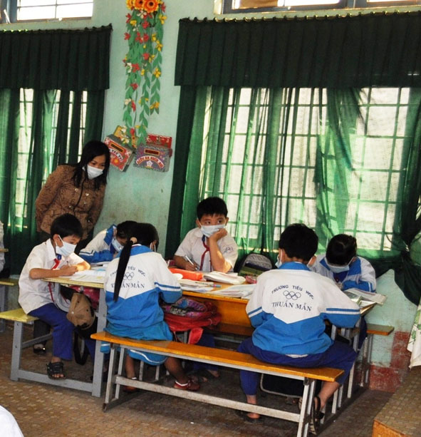 Cô giáo và học sinh Trường Tiểu học Thuận Mẫn phải đeo khẩu trang trong giờ học.