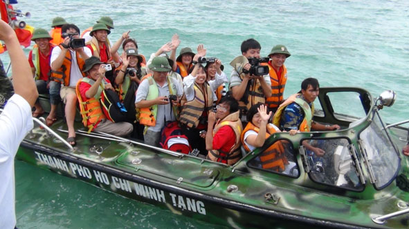 Phóng viên rời tàu lên xuồng vào đảo.