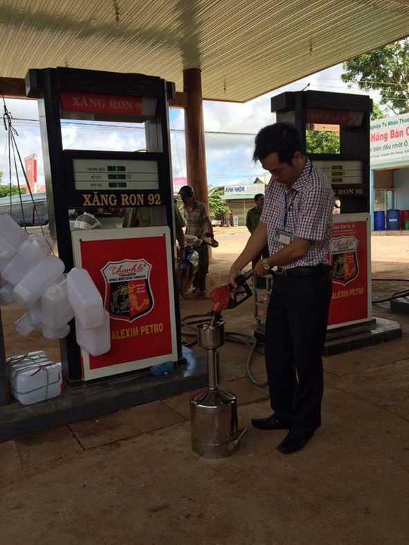 Kiểm tra cột bơm xăng bằng bình chuẩn tại cửa hàng xăng dầu Ngọc Minh, thị trấn Ea Súp, huyện Ea Súp.