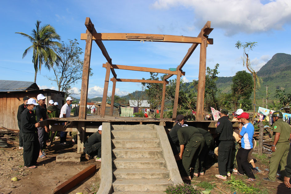 Cán bộ, chiến sĩ Công an tỉnh hỗ trợ người dân xã Yang Mao dựng lại nhà cửa sau bão.