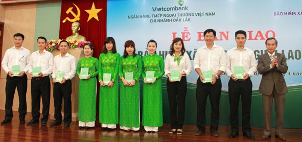 1Ông Trương Văn Sáng (bìa phải), Giám đốc BHXH tỉnh bàn giao sổ BHXH cho cán bộ, nhân viên Ngân hàng TMCP Ngoại thương Việt Nam Chi nhánh Đắk Lắk. Ảnh: N. Xuân