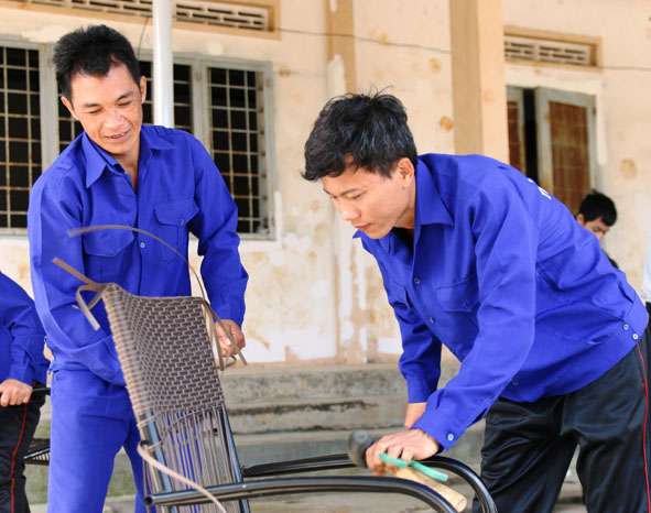 Anh Đỗ Hải Liêm (bìa phải) làm nghề đan ghế nhựa.