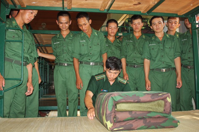 Chiến sĩ mới Tiểu đoàn Huấn luyện Cơ động được cán bộ hướng dẫn gấp nội vụ.