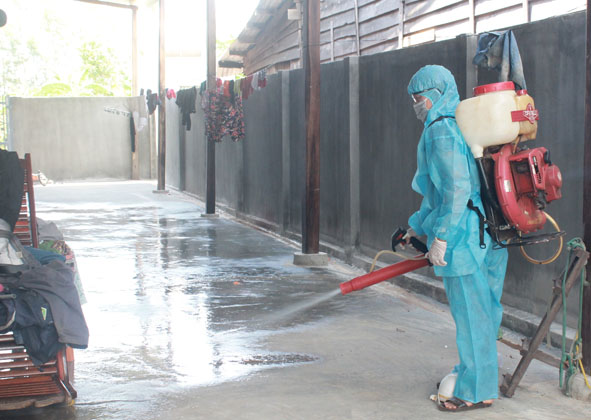 Cán bộ Trung tâm Y tế huyện Ea Súp phun hóa chất Cloramin B khử khuẩn bề mặt tại nhà một bệnh nhân. 