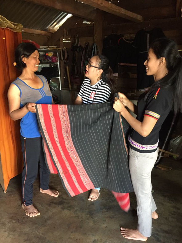 Phóng viên Báo Đắk Lắk (đứng giữa) trong một lần tác nghiệp, tìm hiểu về dệt thổ cẩm.