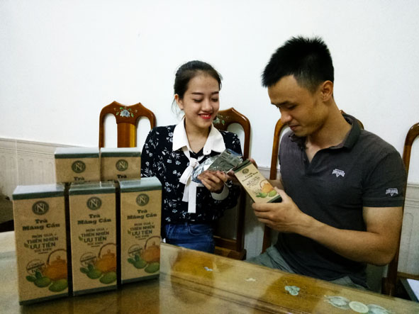 Anh Nguyễn Văn Sơn ( bìa phải ) đang giới thiệu sản phẩm trà mãng cầu.