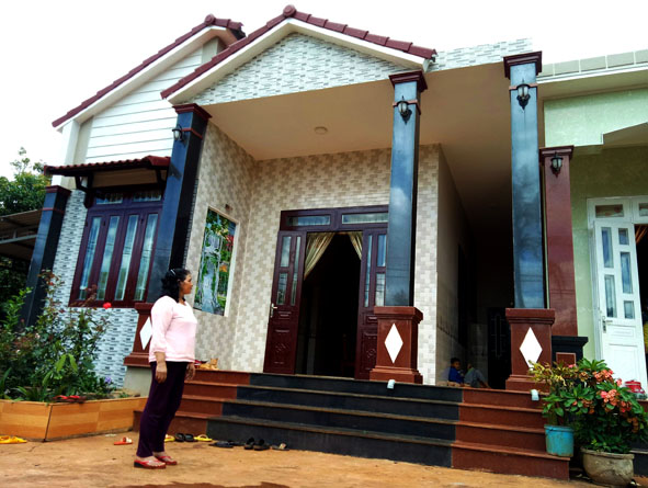 Chị H’Rỗn Niê ở buôn Jũng 2, xã Ea Yông bên ngôi nhà mới của gia đình.