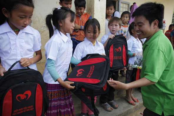 Anh Nguyễn Duy Học trao quà hỗ trợ học sinh vùng khó khăn. 