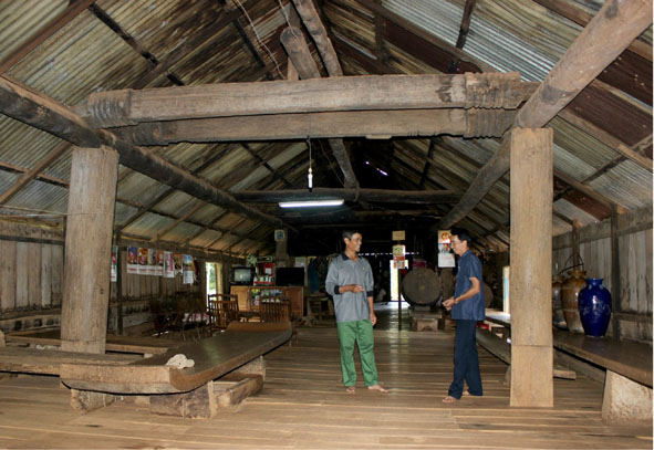 Ông Y Jui (bên trái) giới thiệu ngôi nhà dài với khách tham quan.