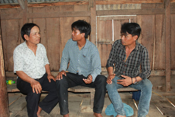 Thanh niên trong buôn nghe ông Y Djuih Mlô (bìa trái) chỉ bảo, chia sẻ.   