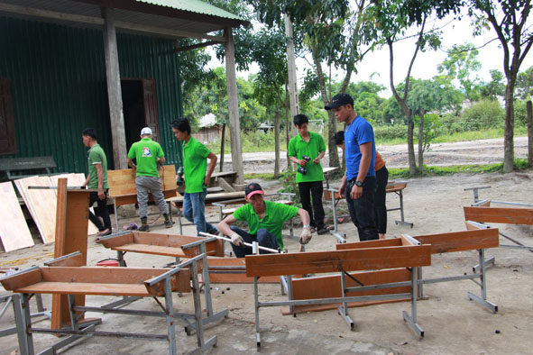 Tình nguyện viên nhóm thiện nguyện Vòng tay yêu thương sửa bàn ghế cho học sinh Trường Tiểu học Bùi Thị Xuân (xã Cư San, huyện M’Đrắk). 