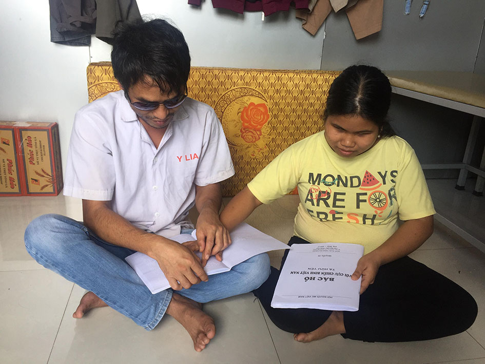 Anh Y Klia và chị H'Gương Êban giúp nhau đọc sách .