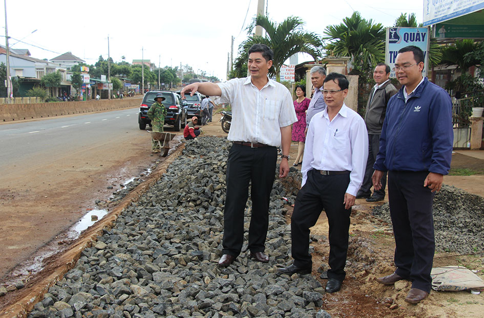 Đồng chí Y Vinh Tơr, Bí thư Thị ủy (bìa trái) thăm công trình lát gạch vỉa hè chào mừng kỷ niệm 10 năm thành lập thị xã  do người dân phường Đạt Hiếu tự đóng góp xây dựng.  Ảnh: L.Hương