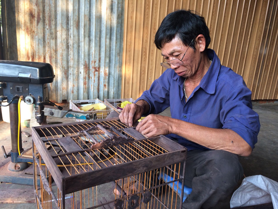 Anh Đức đang hoàn chỉnh một chiếc lồng chim.