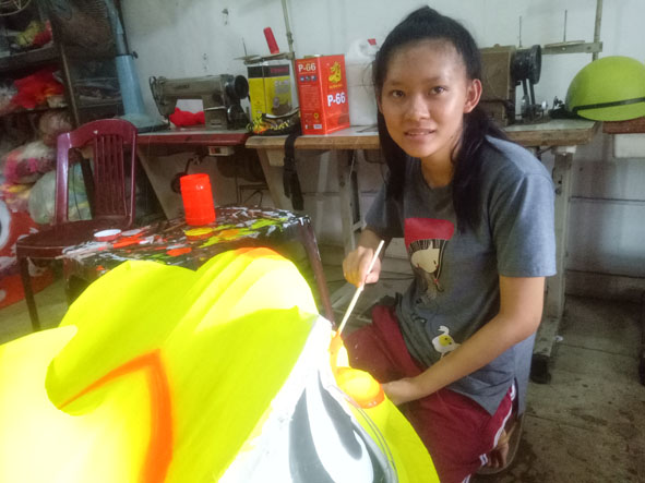 Em Nguyễn Thị Hà đang tô sơn cho đầu lân.