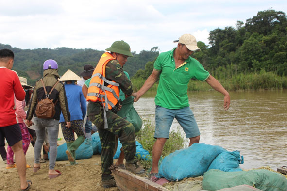 Cán bộ, chiến sĩ Ban Chỉ huy Quân sự huyện Krông Ana cùng nhân dân vận chuyển đất để 