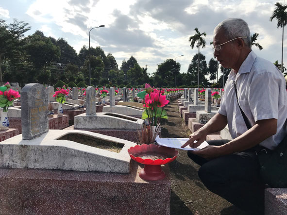 Ông Nguyễn Ngọc Sương, Ủy viên Ban liên lạc truyền thống Trung đoàn 25 - Tây Nguyên đang đối chiếu kết quả danh tính hài cốt liệt sỹ tại lô E - Nghĩa trang Liệt sỹ tỉnh.