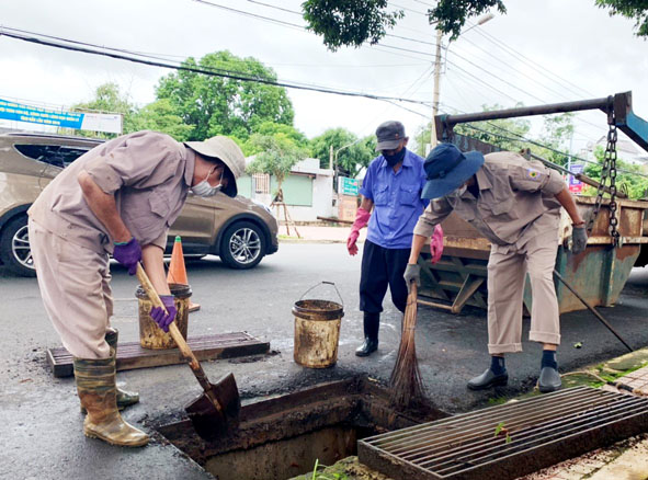 Công nhân Công ty Cổ phần Đô thị và Môi trường Đắk Lắk vệ sinh cống thoát nước sau mưa lớn.