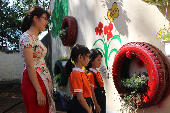 Các em học sinh thích thú ngắm nhìn những giỏ hoa sáng tạo.