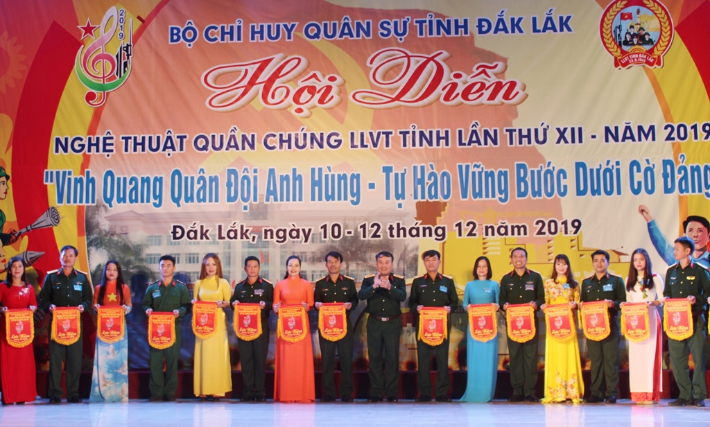 Thượng tá Trần Minh Trọng, Chính ủy Bộ Chỉ huy Quân sự tỉnh trao cờ lưu niệm tặng các Đoàn nghệ thuật