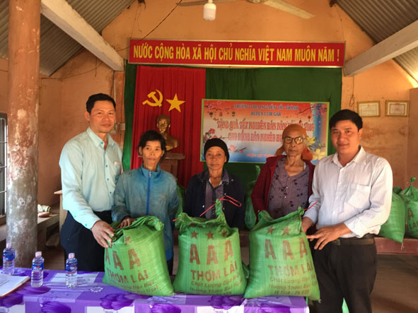 Lãnh đạo Trường THCS Nguyễn Tất Thành, chính quyền địa phương trao quà Tết tặng các hộ nghèo buôn kết nghĩa Ka Na A. 