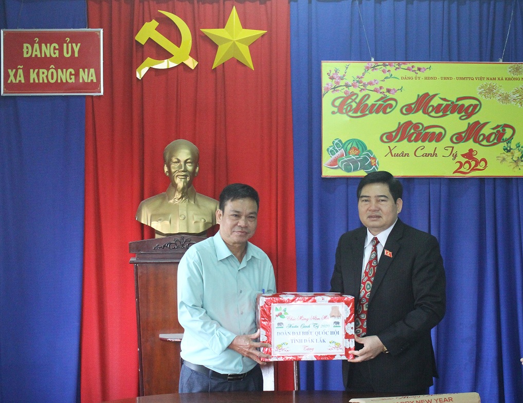Phó trưởng Đoàn Chuyên trách Đoàn Đại biểu Quốc hội tỉnh Y Khút Niê tặng quà cho đại diện lãnh đạo xã Krông Na