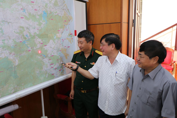 Bí thư Tỉnh ủy Bùi Văn Cường (giữa) và các đại biểu khảo sát Dự án đường cao tốc Buôn Ma Thuột - Nha Trang trên bản đồ tại hội thảo. Ảnh: Hoàng Gia