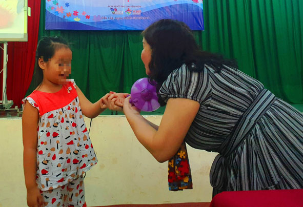 Chuyên gia Lê Thị Thanh Xuân dùng bóng bay thu hút sự chú ý của trẻ.