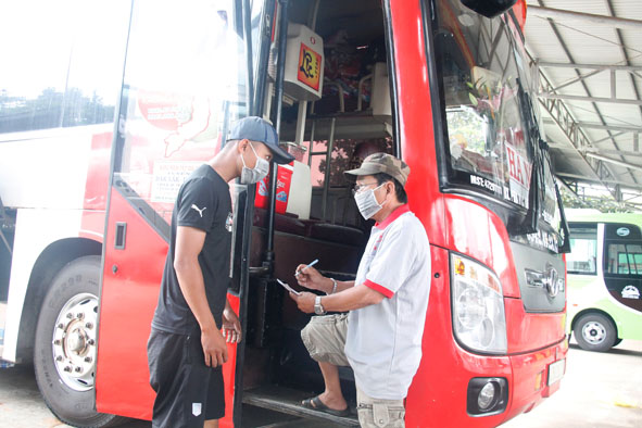 Nhân viên nhà xe hướng dẫn khách đi xe kê khai y tế bắt buộc.