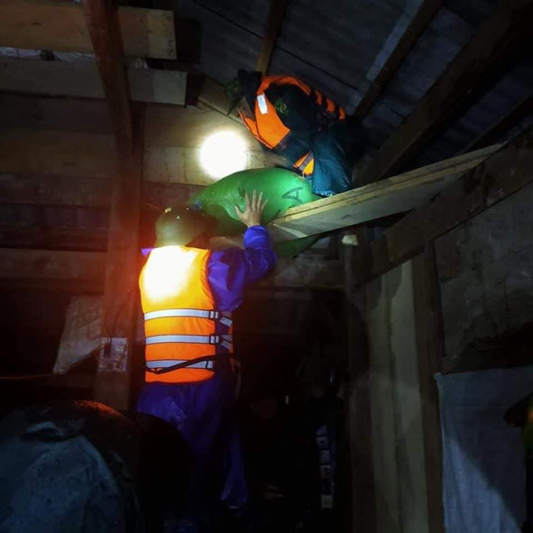 Bộ đội, dân quân hỗ trợ người dân kê đặt tài sản, thóc lúa lên cao tránh lũ. Ảnh. Nhất Vũ