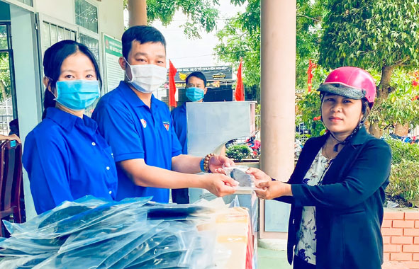 Đoàn viên thanh niên thị trấn Quảng Phú (huyện Cư M'gar) phát khẩu trang miễn phí cho người dân đến làm CCCD.